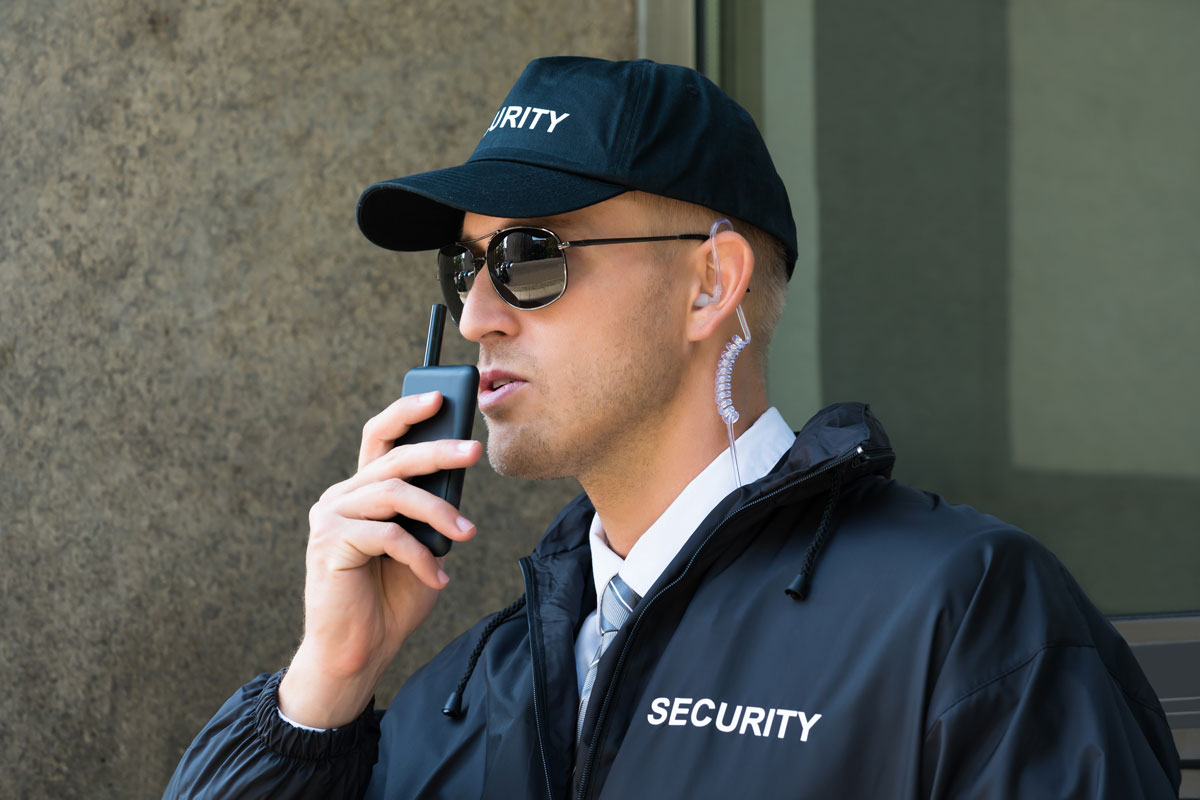 formation tfp aps à paris - un agent de sécurité debout devant une porte avec un talkie walkie